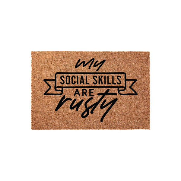 Funny My Social Skills Are Rusty coir doormat featuring a natural brown fiber texture and bold black typography, designed as a humorous front porch welcome mat for guests with a witty sense of humor and a casual home decor style.