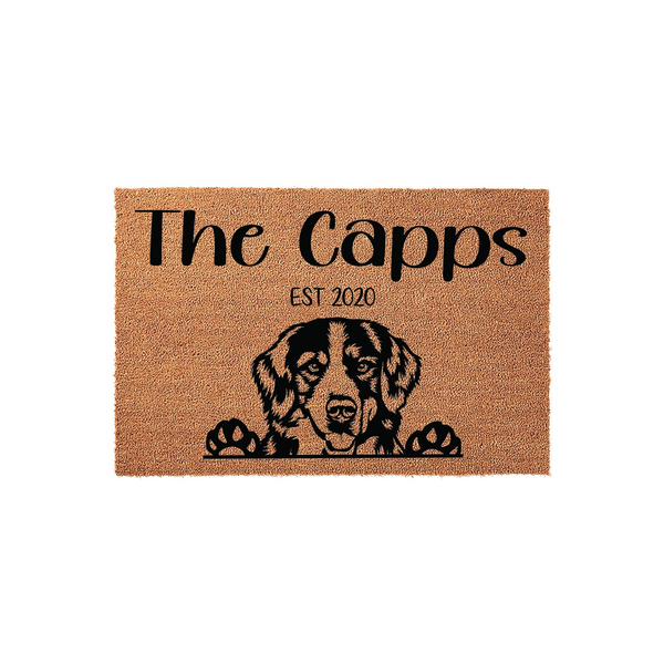 Personalized Bernese Mountain Dog doormat featuring a cute dog illustration peeking over the bottom edge, printed on a natural coir fiber mat with custom family name text and established year for a welcoming front porch entrance.