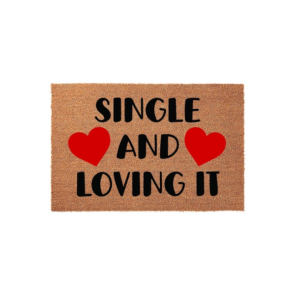 Single and Loving It coir doormat featuring bold black text and two bright red hearts on a natural tan fiber background, creating a fun and welcoming entrance decor piece for any apartment or home entryway that celebrates