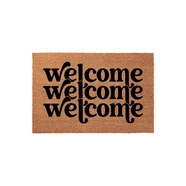 Welcome coir doormat featuring a modern layered typography design with the word welcome printed three times in bold black ink against a natural tan textured fiber background, creating a stylish entryway decor piece for your front