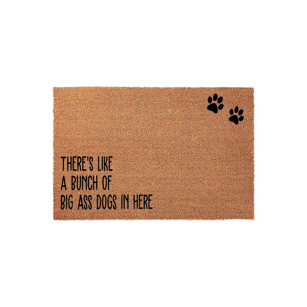 Funny Dog Lover Coir Doormat featuring the text There is like a bunch of big ass dogs in here printed in black ink, accented by two black paw prints on a natural brown textured coir fiber mat against a clean white studio