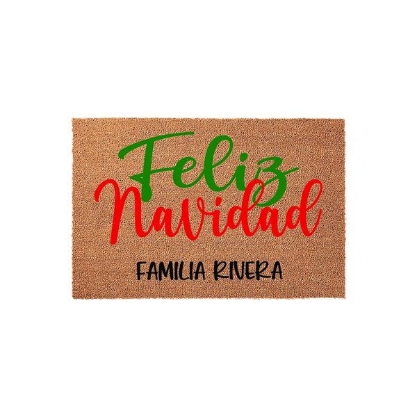 Personalized Feliz Navidad coir doormat featuring festive red and green script lettering on a natural brown fiber background, customized with a family name at the bottom to welcome guests to your home during the holiday season.