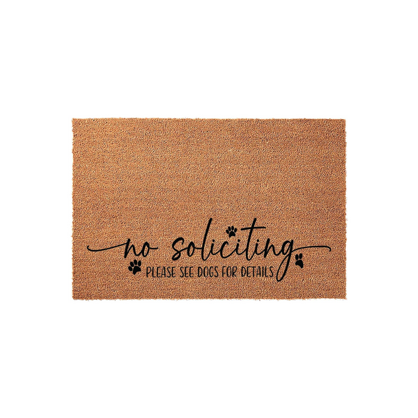 No Soliciting Please See Dogs For Details doormat made of natural coir fiber, featuring black script lettering and cute paw print accents on a plain white background for a funny and functional front porch decor piece.