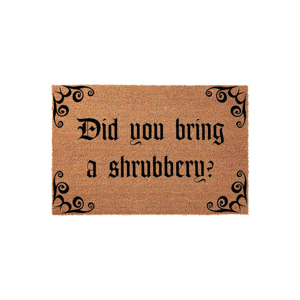 Funny movie quote doormat featuring the text Did you bring a shrubbery in a bold gothic font, set against a natural brown coir fiber background with decorative black scrollwork accents in each of the four corners of the