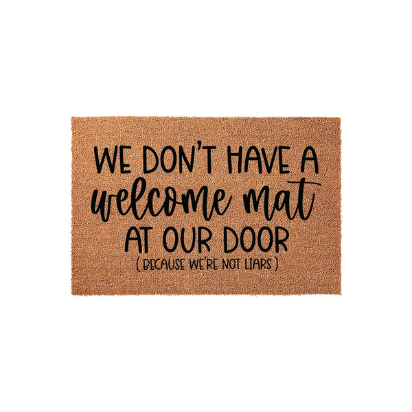 Funny Coir Doormat with the text We Don't Have A Welcome Mat At Our Door Because We're Not Liars printed in black ink, featuring a natural brown fiber texture on a clean white background for a humorous front porch entryway decor.
