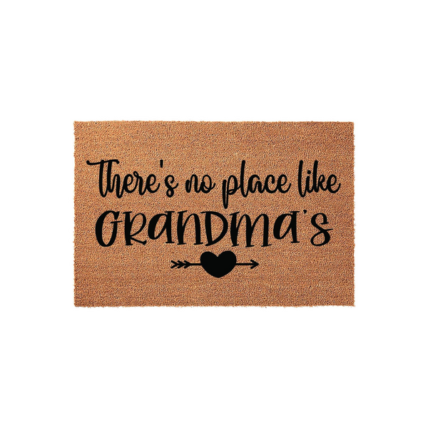 Grandma coir doormat featuring the text There is no place like Grandma's in black script lettering, accented by a small heart and arrow icon on a natural brown fiber background for a welcoming front porch entryway decor piece.