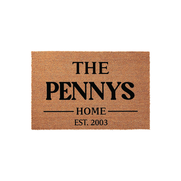 Personalized family name coir doormat featuring a natural tan fiber texture with bold black text that reads The Pennys Home Est. 2003, creating a welcoming entrance piece for a front porch or entryway that celebrates a family