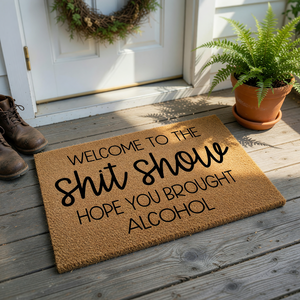 Funny Welcome To The Shit Show Hope You Brought Alcohol doormat featuring bold black typography printed on a natural tan coir fiber mat, creating a humorous and inviting entryway decor piece for your home front porch or apartment