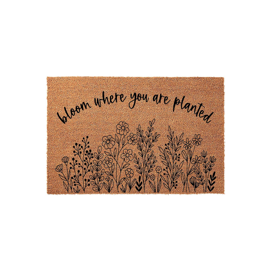 Bloom Where You Are Planted coir doormat featuring a natural tan fiber texture and a black ink illustration of wildflowers at the bottom, creating a welcoming front porch entrance with a charming botanical design for your home