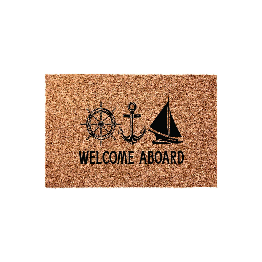 Nautical Welcome Aboard doormat made of natural coir fiber, featuring a black printed design of a ship wheel, an anchor, and a sailboat centered above the text on a rectangular mat against a clean, plain white studio background.