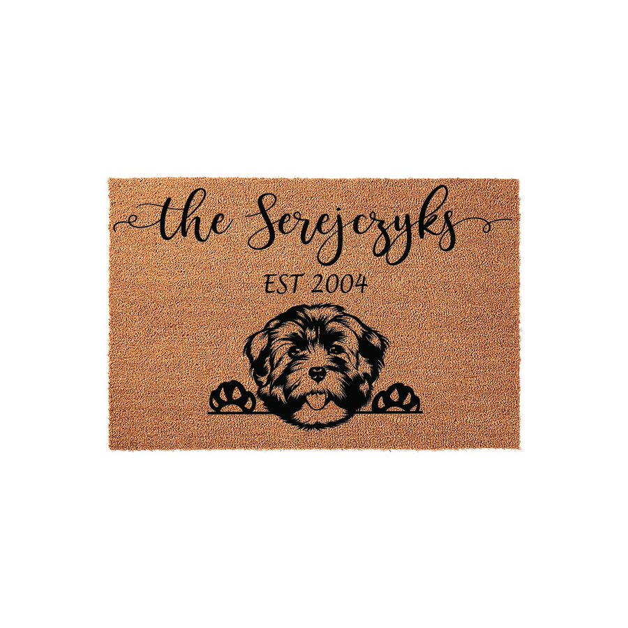 Personalized Havanese dog doormat featuring a cute illustrated puppy peeking over the bottom edge, printed on a natural coir fiber mat with a custom family name and established year in elegant black script and block lettering.