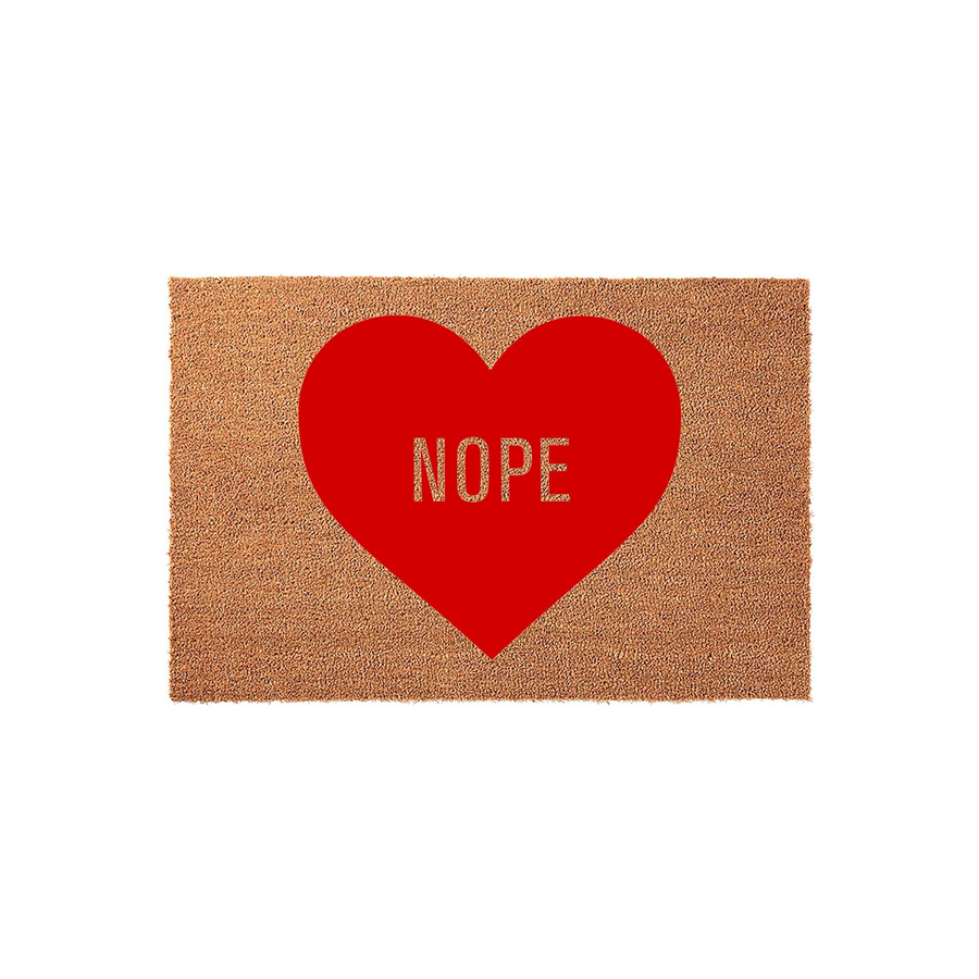 Nope Heart Coir Doormat featuring a natural brown coconut fiber texture with a large, bold red heart graphic in the center, which displays the word NOPE in a clean, modern font against a plain white studio background for a funny