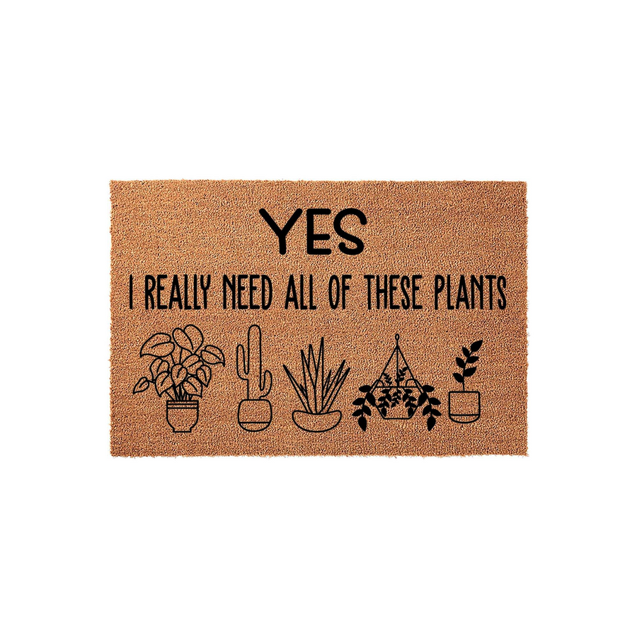 Plant Lover Coir Doormat featuring the text Yes I Really Need All Of These Plants in black ink, accompanied by five simple line-art illustrations of various potted houseplants on a natural brown textured fiber background.
