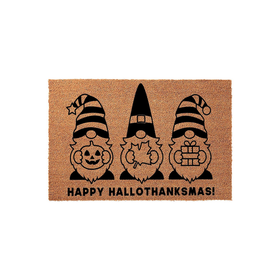 Happy Hallothanksmas Gnome Doormat featuring three cute gnomes holding a pumpkin, a maple leaf, and a gift box, printed in black on a natural tan coir fiber mat to celebrate the fall and winter holiday season at your front door