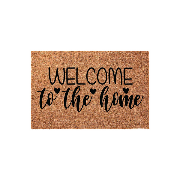 Welcome to the home coir doormat featuring a natural tan fiber texture and bold black lettering with small heart accents, providing a warm and inviting entrance decor piece for your front porch or entryway on a clean white