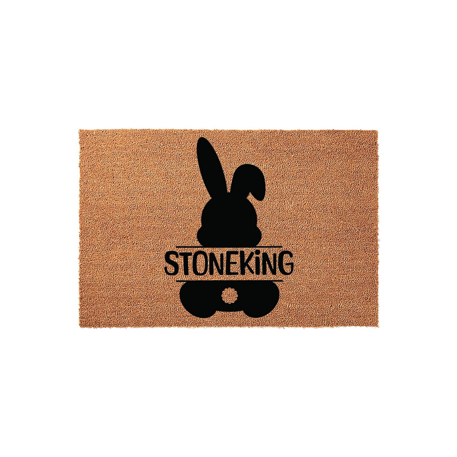 Personalized Easter Bunny Coir Doormat featuring a black silhouette of a rabbit with a fluffy tail and a central horizontal line for a custom family name, set against a natural brown textured coconut fiber background for a