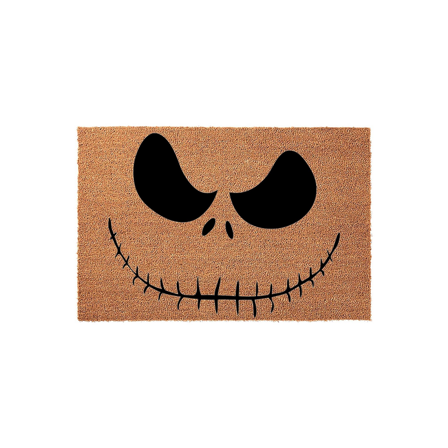Jack Skellington Halloween doormat featuring a natural coir fiber texture with the iconic black stitched smile and hollow eyes printed in the center, creating a spooky and festive entryway decor piece for the fall holiday season.
