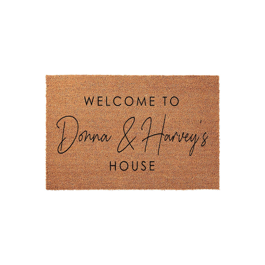Personalized coir doormat featuring a natural tan fiber texture and black printed text that reads Welcome to our house, providing a warm and inviting entryway accent for any home front porch or apartment door decor.