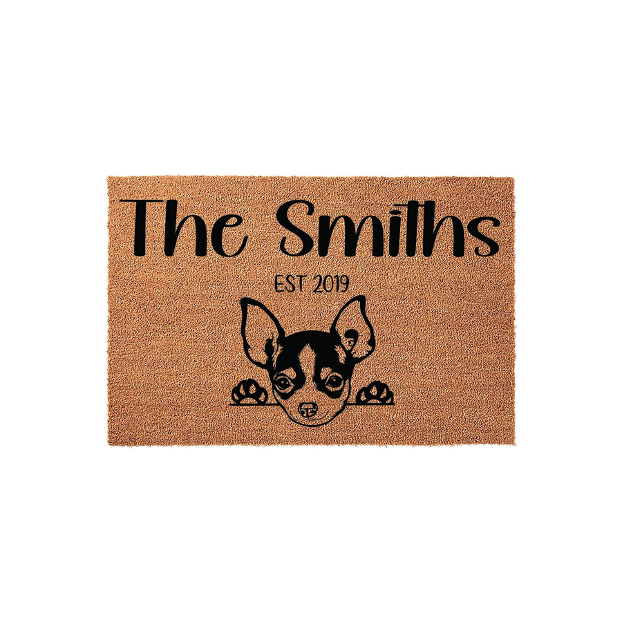 Personalized Chihuahua family doormat featuring a cute dog illustration peeking over the edge, customized with a family name and established year on a durable natural coir fiber mat for a welcoming front porch entrance.