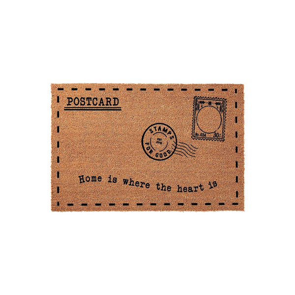 Postcard design coir doormat featuring a vintage mail aesthetic with a stamp graphic and the text Home is where the heart is printed in black ink on a natural brown textured fiber surface against a clean white background.