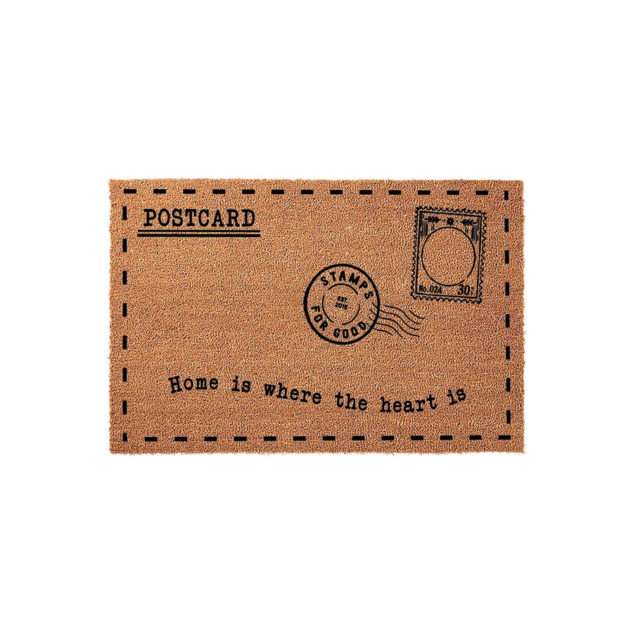 Postcard design coir doormat featuring a vintage mail aesthetic with a stamp graphic and the text Home is where the heart is printed in black ink on a natural brown textured fiber surface against a clean white background.