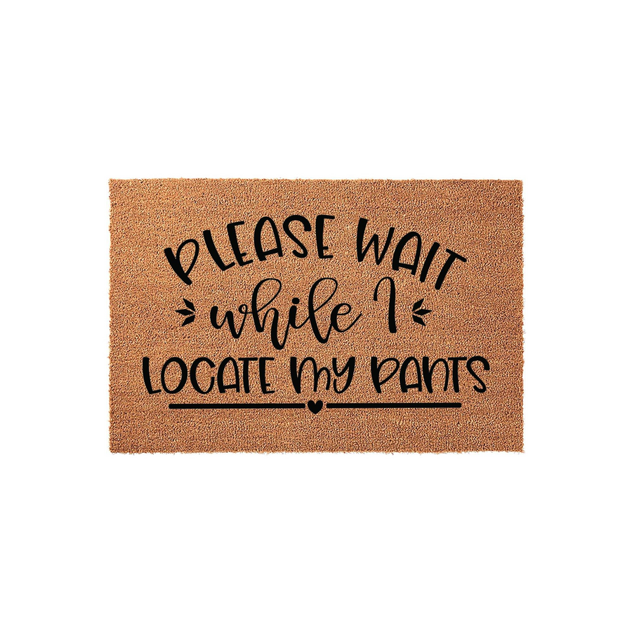 Funny Welcome Doormat featuring the text Please Wait While I Locate My Pants in black script and block lettering on a natural coir fiber mat, creating a humorous and inviting entryway decor piece for your front porch or home