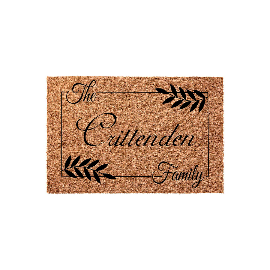 Personalized family name coir doormat featuring a classic rectangular border, elegant black script lettering, and decorative leaf accents on a natural tan textured fiber background for a welcoming front porch entryway decor style.