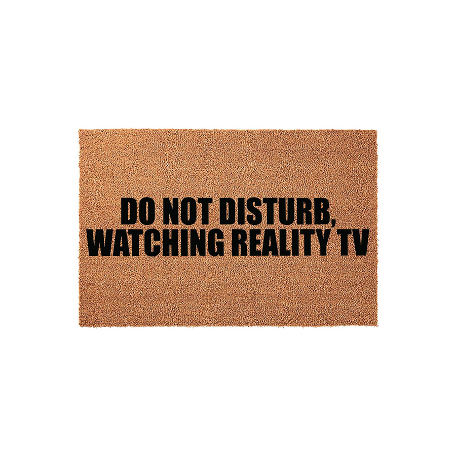 Do Not Disturb Watching Reality TV coir doormat featuring bold black text printed on a natural brown coconut fiber mat, providing a humorous and functional welcome for any front porch or entryway in a clean, isolated studio
