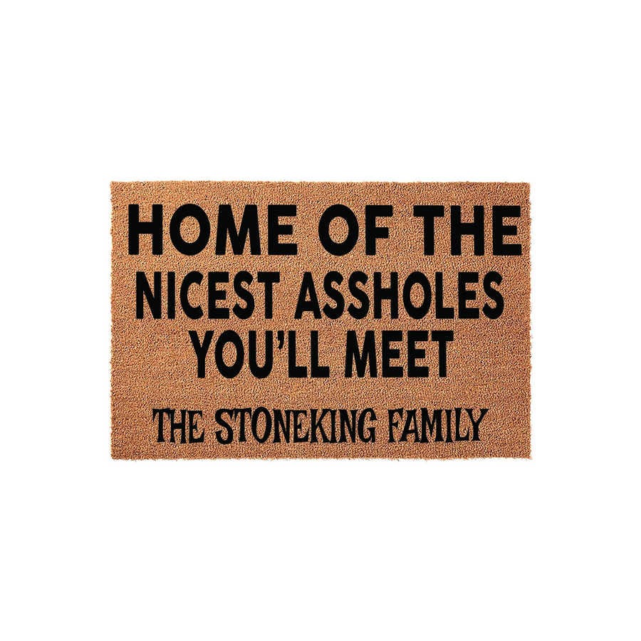 Personalized funny doormat featuring a natural coir texture with bold black text that reads Home of the Nicest Assholes You Will Meet followed by a custom family name line, perfect for a humorous and welcoming front porch