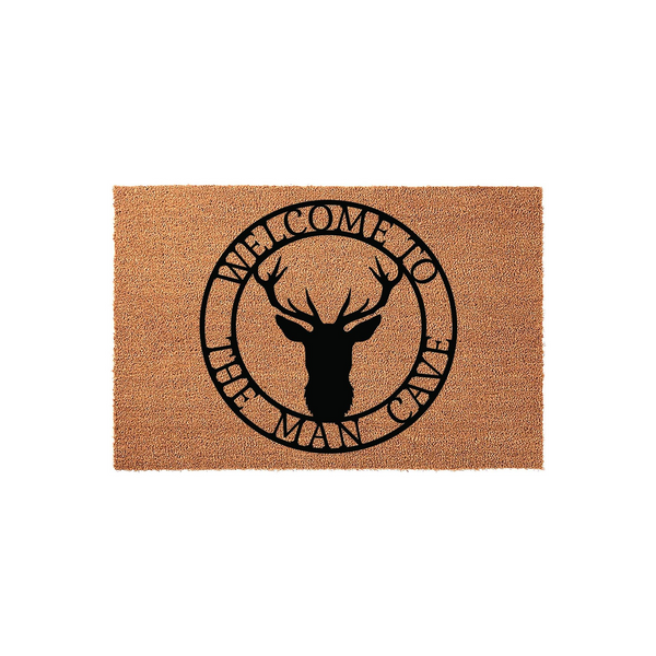 Man Cave Welcome Doormat featuring a rustic deer head silhouette centered within a circular frame, printed in bold black ink on a natural tan coir fiber mat that adds a rugged, outdoorsy touch to any home entrance or garage