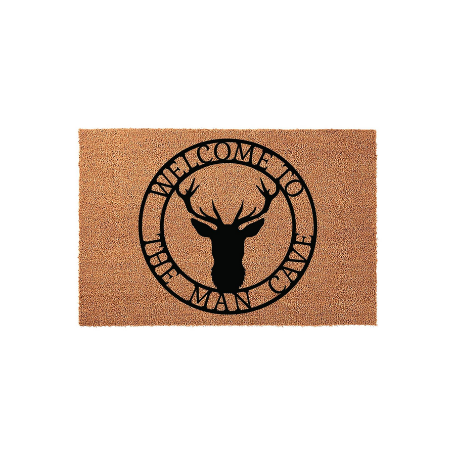 Man Cave Welcome Doormat featuring a rustic deer head silhouette centered within a circular frame, printed in bold black ink on a natural tan coir fiber mat that adds a rugged, outdoorsy touch to any home entrance or garage