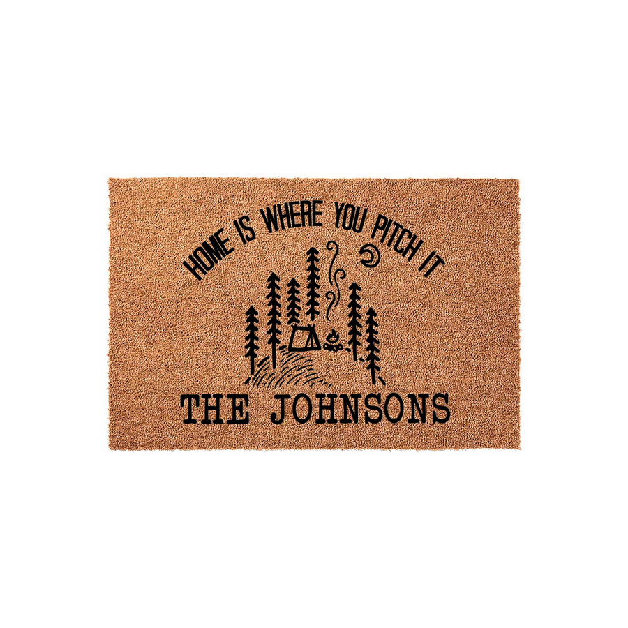 Personalized Camping Doormat featuring a rustic forest, tent, and campfire design with the text Home Is Where You Pitch It, set against a natural coir fiber background that adds a welcoming touch to any outdoor entryway or porch