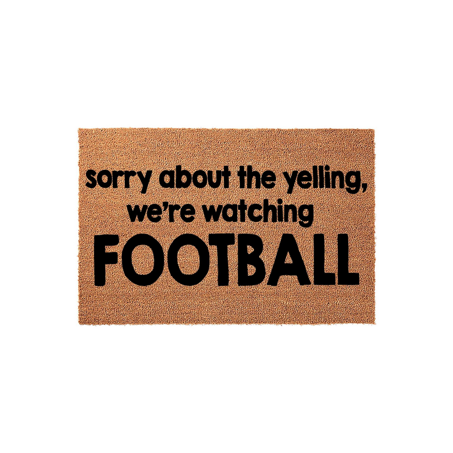 Funny Football Welcome Doormat featuring natural coir fibers and bold black text that reads sorry about the yelling, we are watching FOOTBALL, making it a humorous front porch decor piece for any sports fan home entrance.