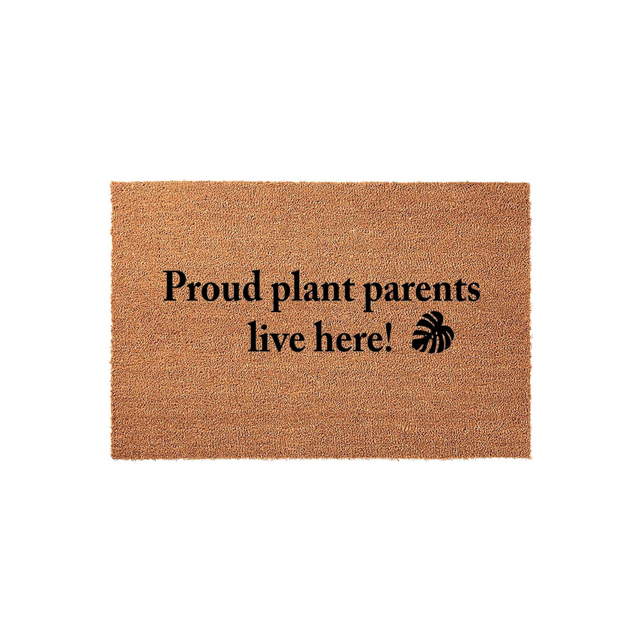 Proud plant parents live here coir doormat featuring a natural brown fiber texture and bold black text with a monstera leaf icon, perfect for a housewarming entrance decor update for any indoor or outdoor home entryway space.