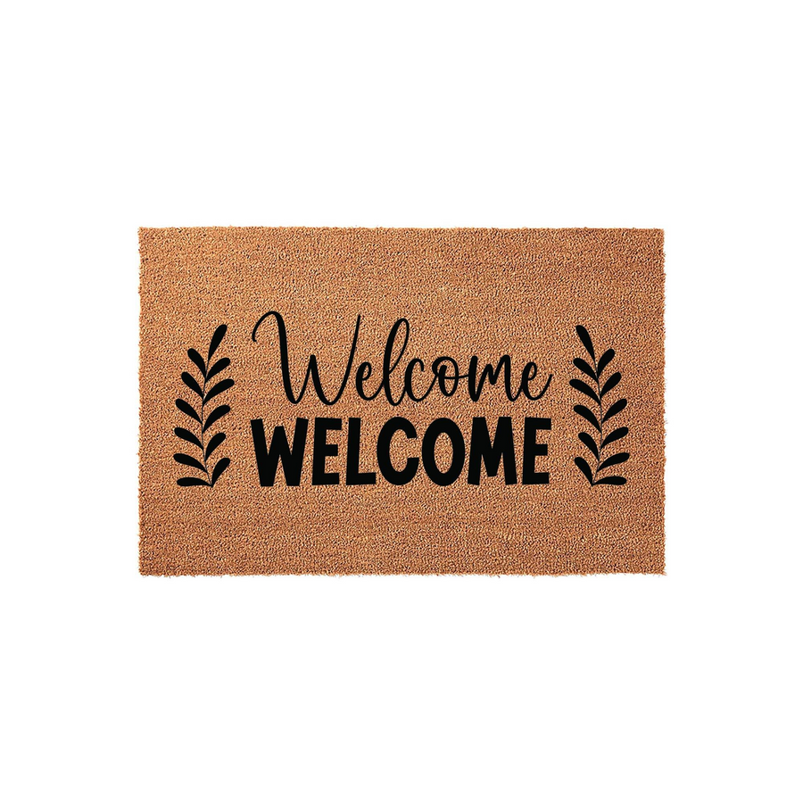 Natural coir welcome doormat featuring a double welcome design with elegant script and bold block lettering, flanked by simple black leaf sprigs on a textured brown fiber background for a classic farmhouse entryway decor style.
