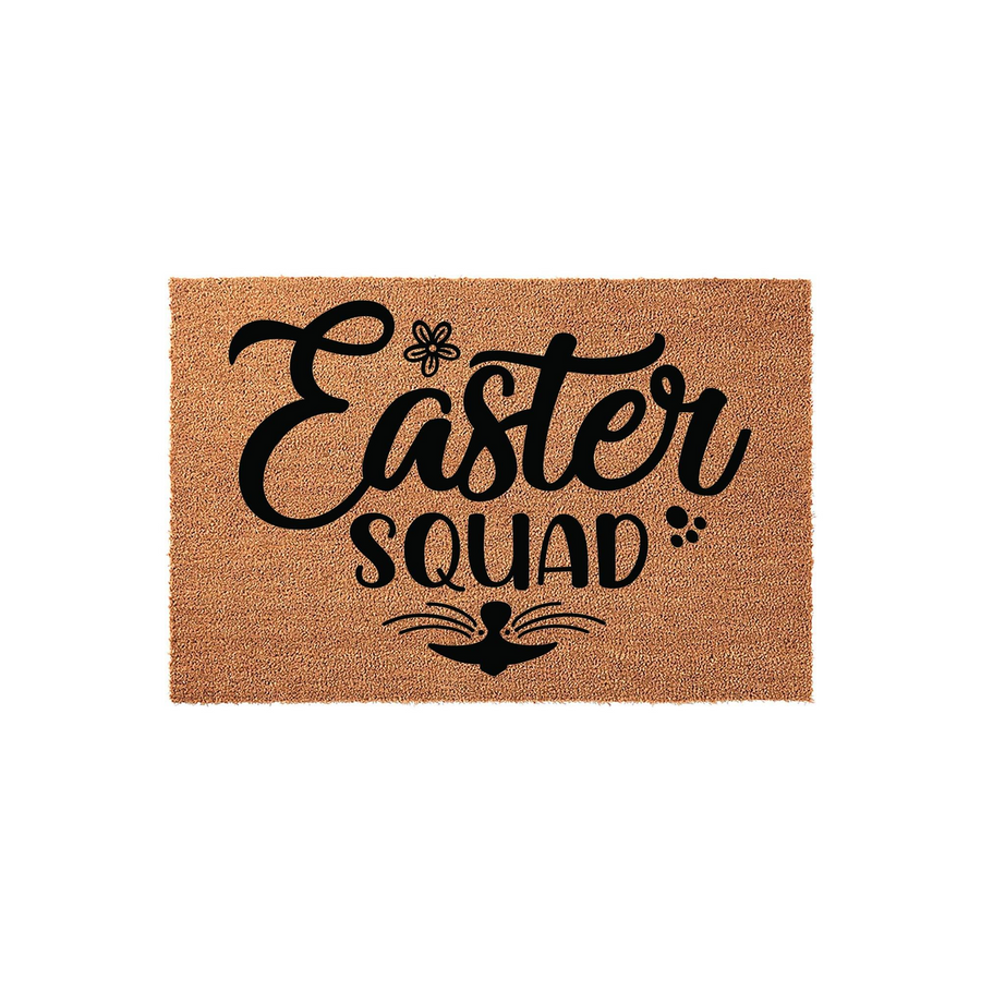 Easter Squad coir doormat featuring black text in a decorative script font, accented with a small flower, paw prints, and a bunny nose with whiskers, set against a natural brown textured fiber background for a festive spring