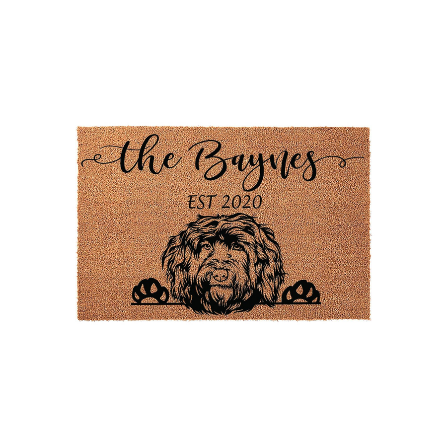 Personalized Doodle Dog Doormat featuring a custom family name and established year printed in black on a natural coir fiber mat, showcasing a detailed illustration of a shaggy dog peeking over the bottom edge with its paws