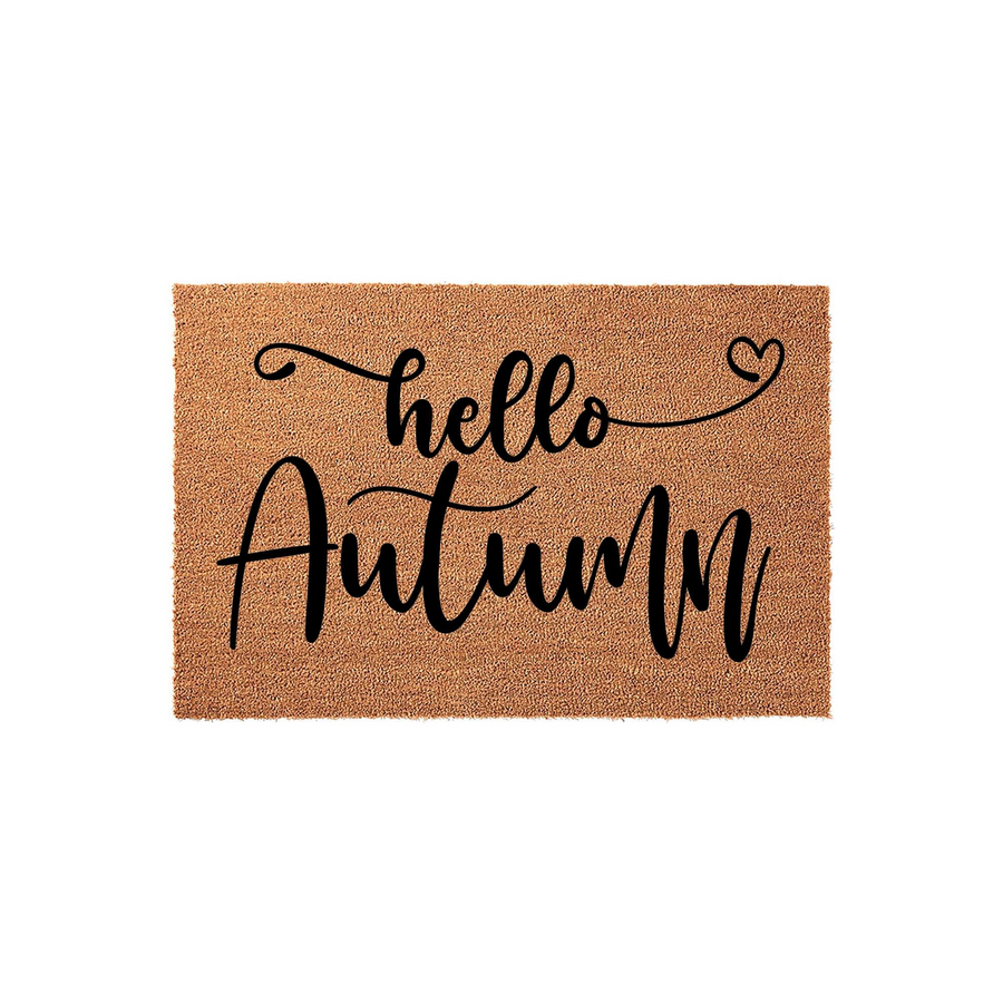 Hello Autumn coir doormat featuring a natural brown fiber texture with black script lettering that reads hello autumn, accented by a small heart design on a clean white background for a festive seasonal front porch entryway decor.