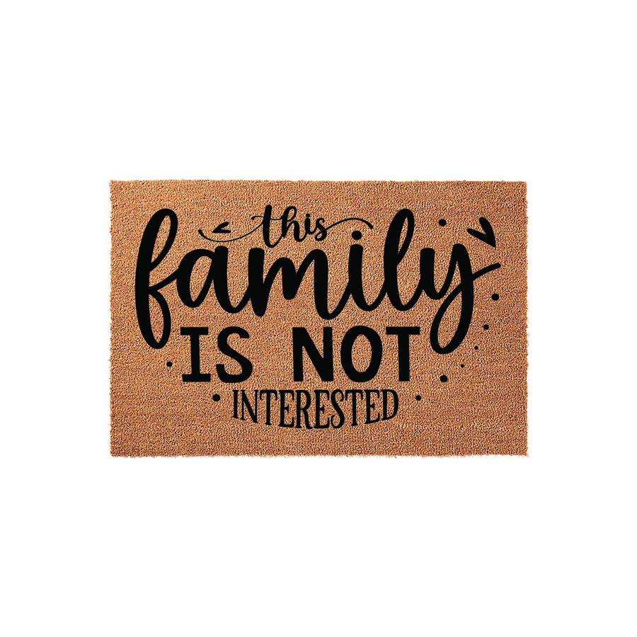 Funny This Family Is Not Interested coir doormat featuring bold black typography on a natural brown coconut fiber background, designed to keep solicitors away from your front porch with a humorous and welcoming home decor
