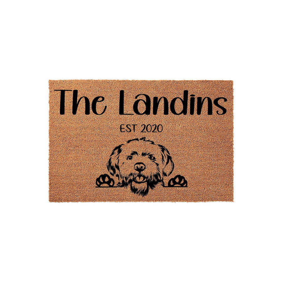 Personalized Doodle Dog Doormat featuring a cute shaggy dog illustration, custom family name text, and established year on a natural coir fiber mat, perfect for a welcoming front porch entrance for any dog-loving household.