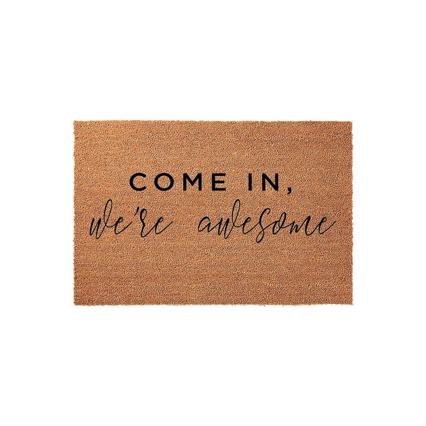 Funny Welcome Doormat featuring a natural coir fiber texture and bold black text that reads Come In, we're awesome, making this a humorous and inviting front porch decor piece for any home entrance or apartment doorway.