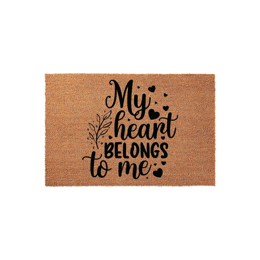 My Heart Belongs To Me coir doormat featuring a natural tan fiber texture with bold black typography and decorative heart and leaf accents, creating a charming and welcoming entrance piece for any home front porch or entryway.