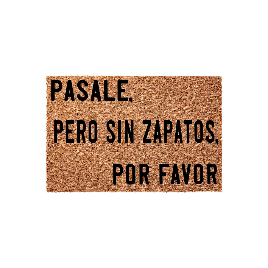 Spanish language coir doormat featuring the phrase Pasale, pero sin zapatos, por favor in bold black lettering, set against a natural tan fiber background to create a welcoming and humorous entrance for your home or apartment