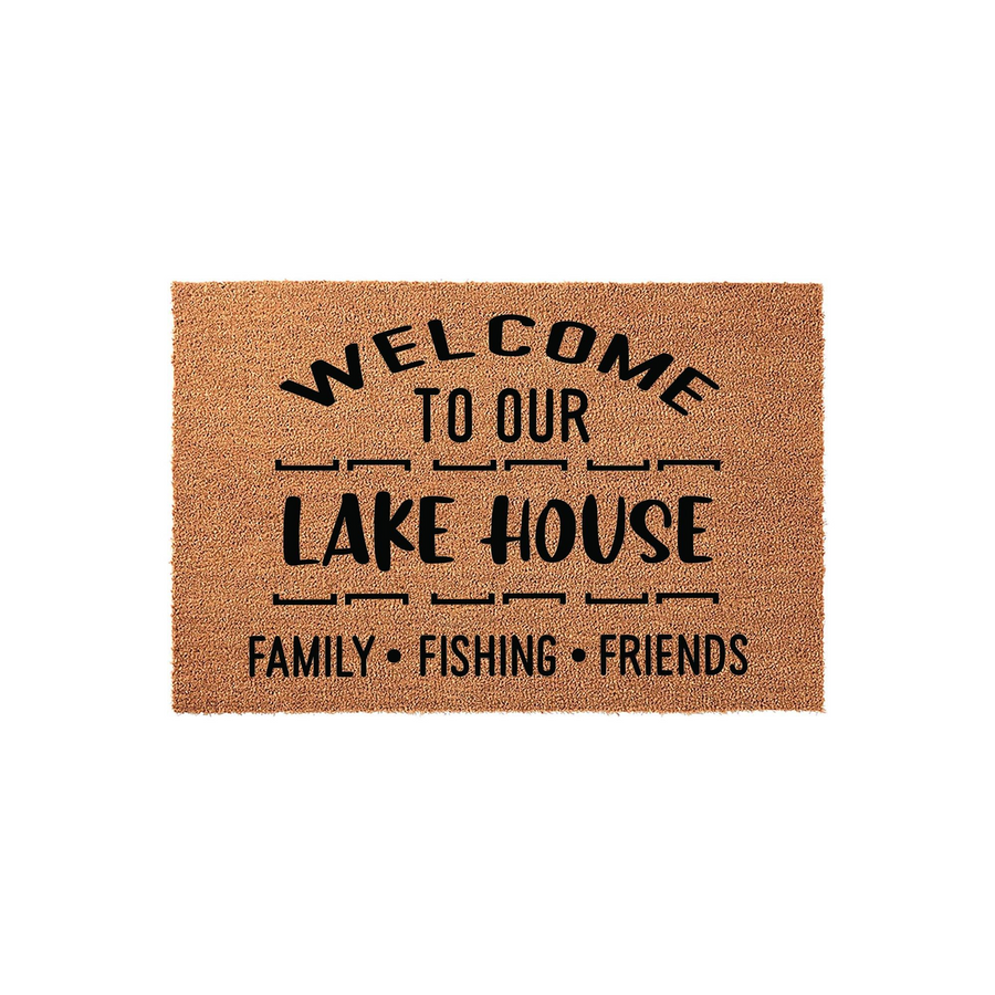 Lake House Welcome Doormat featuring a natural coir texture with bold black text that reads Welcome To Our Lake House, followed by the words Family, Fishing, and Friends, set against a clean white studio background for a rustic