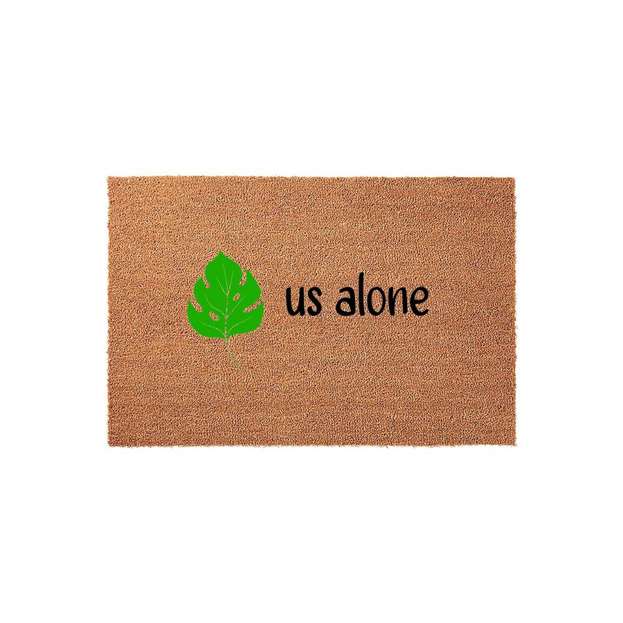 Monstera Leaf Welcome Doormat featuring a natural coir texture with a bright green tropical leaf illustration and the text us alone printed in a simple black font, centered on a clean white studio background for a modern entryway.