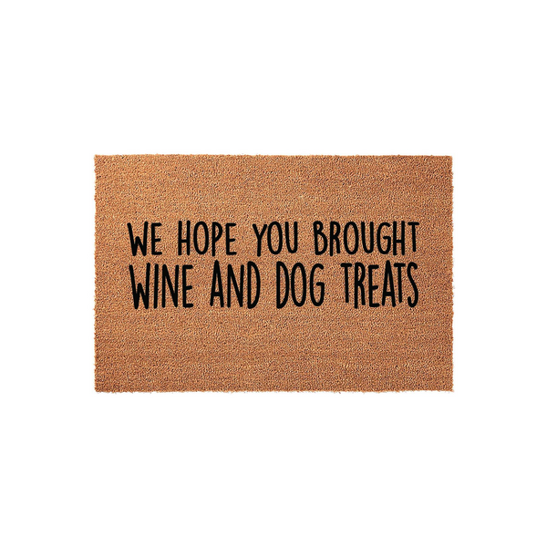Funny Wine and Dog Treats Doormat featuring a natural coir texture with bold black lettering that reads We Hope You Brought Wine and Dog Treats, making it a humorous and welcoming addition to any pet lover's front porch entryway.