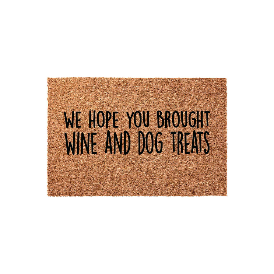 Funny Wine and Dog Treats Doormat featuring a natural coir texture with bold black lettering that reads We Hope You Brought Wine and Dog Treats, making it a humorous and welcoming addition to any pet lover's front porch entryway.