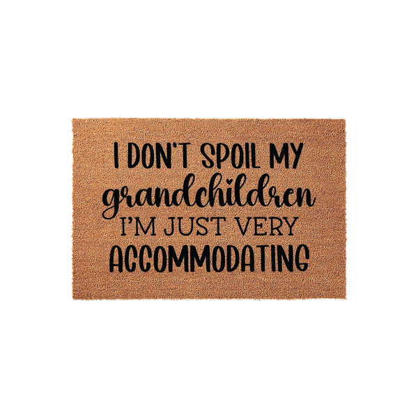 Funny Grandchildren Coir Doormat featuring the text I don't spoil my grandchildren, I'm just very accommodating in black lettering on a natural brown fiber mat, making a humorous entryway decor piece for a proud grandparent's