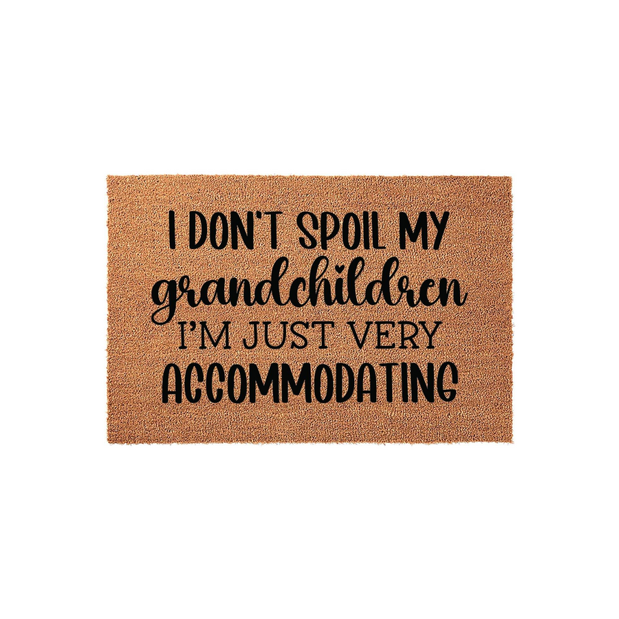 Funny Grandchildren Coir Doormat featuring the text I don't spoil my grandchildren, I'm just very accommodating in black lettering on a natural brown fiber mat, making a humorous entryway decor piece for a proud grandparent's