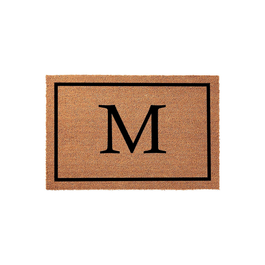 Personalized monogram coir doormat featuring a large black letter M centered within a simple rectangular border, set against a clean white background to showcase the natural tan texture of the durable outdoor welcome mat material.